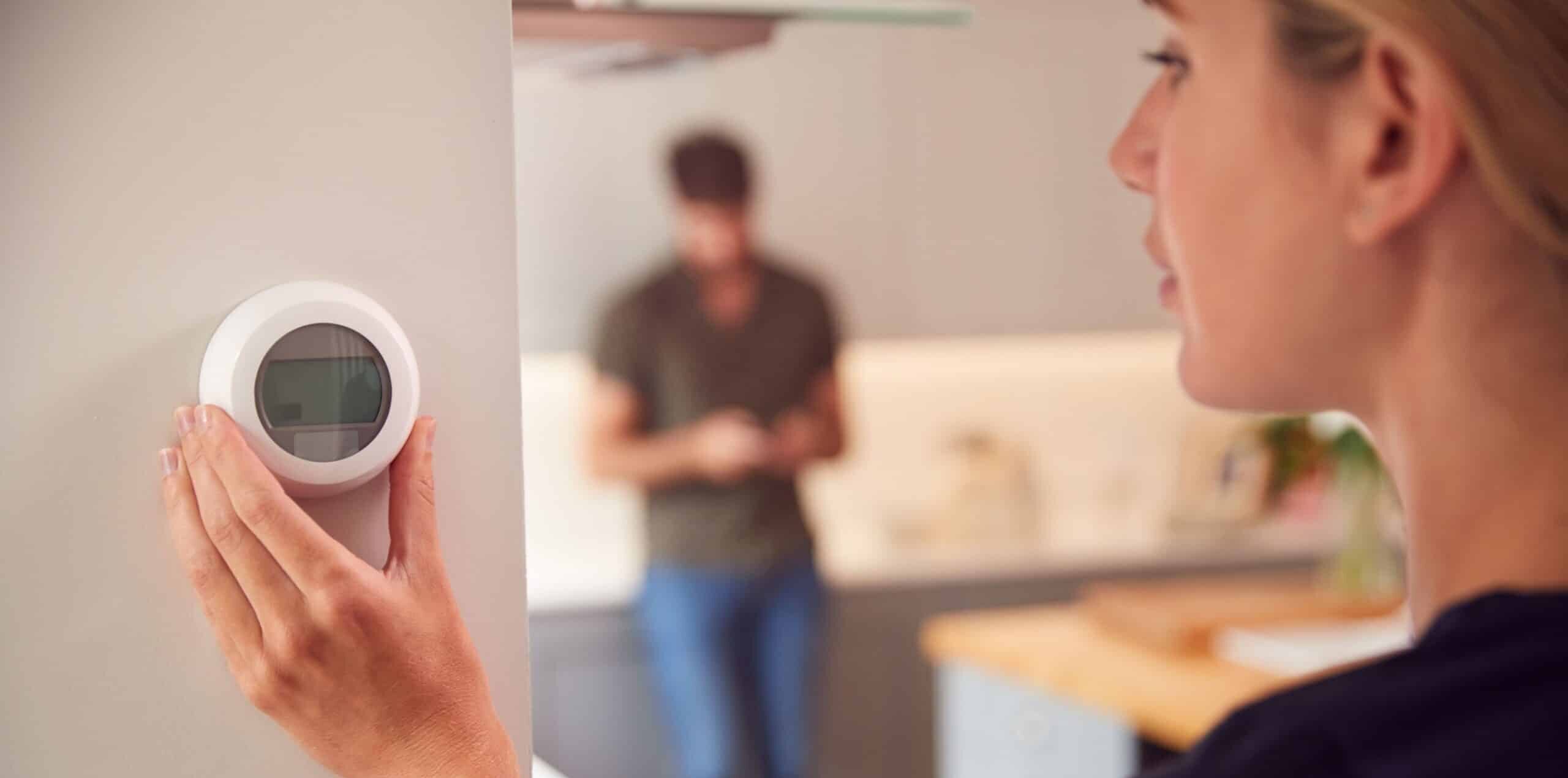 Person at home adjusting thermostat