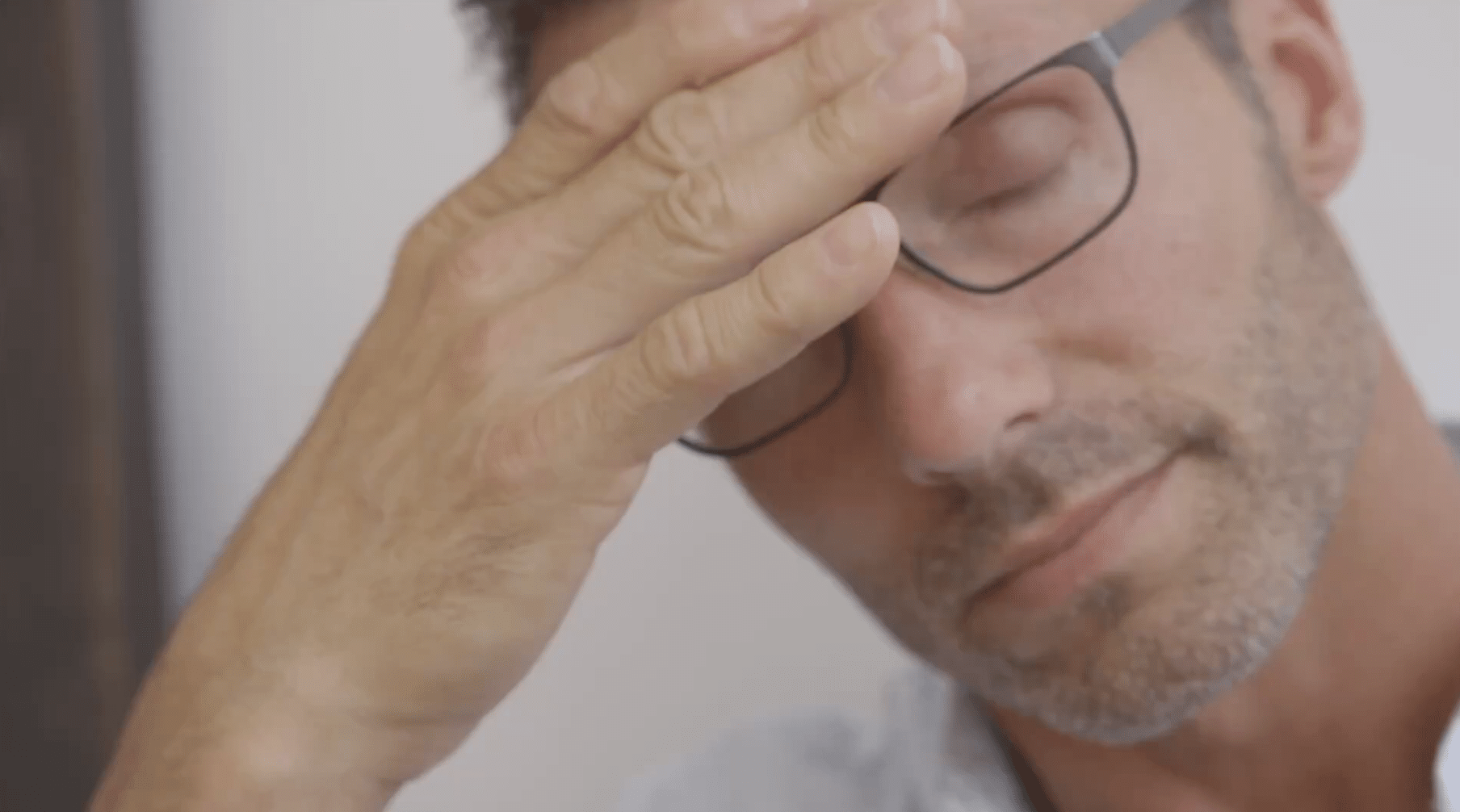 Stressed man rubbing his forehead